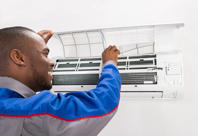 A technician tuning up an air conditioning unit in Knoxville, TN