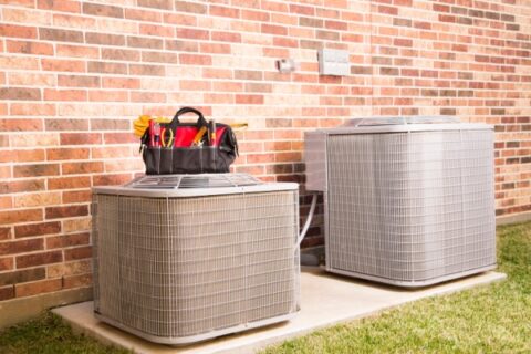 Outdoor AC units with tools for maintenance by Grissom Heat & Air in Knoxville, TN